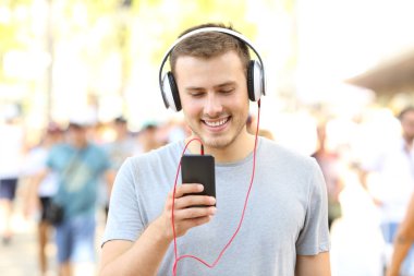 Çocuk sokakta yürürken müzik dinlemek