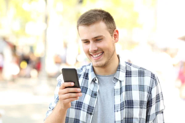 Ragazzo che legge messaggi al telefono per strada — Foto Stock
