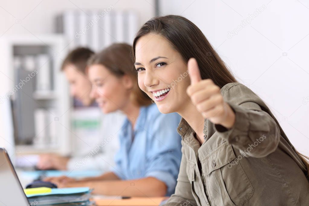 Proud worker with thumbs up at office