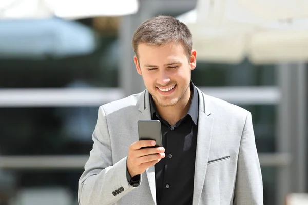 Zakenman wandelen en SMS op telefoon — Stockfoto