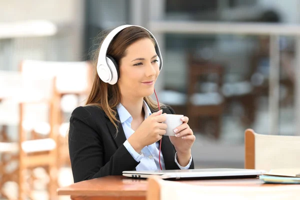 Femme d'affaires écoutant de la musique pendant une pause café — Photo