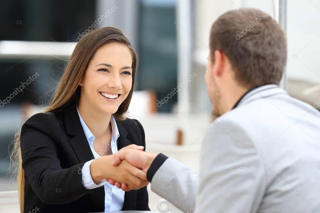 Executives handshaking in a coffee shop