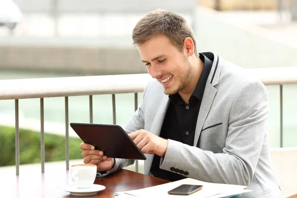 Executivo trabalha com um tablet em uma cafeteria — Fotografia de Stock