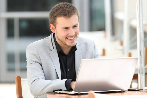 Verkställande skriver i en laptop på kafé — Stockfoto