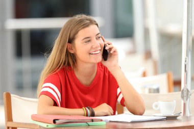 Bir barda telefonda konuşurken mutlu öğrenci