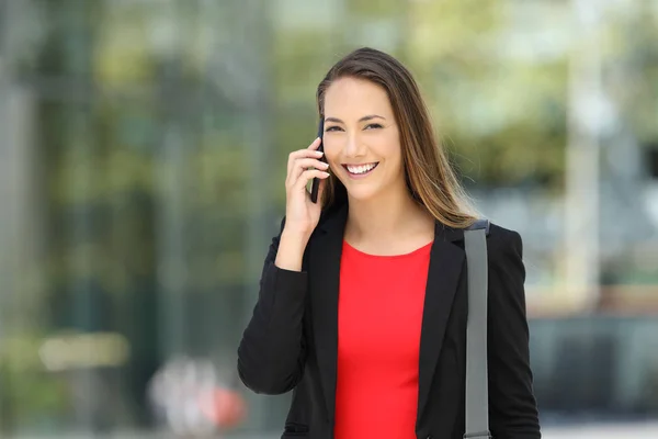 Executive talking on phone looking at camera on the street — Stock Photo, Image