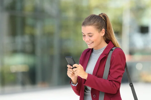 Young businesswoman using phone on the street — Stock Photo, Image