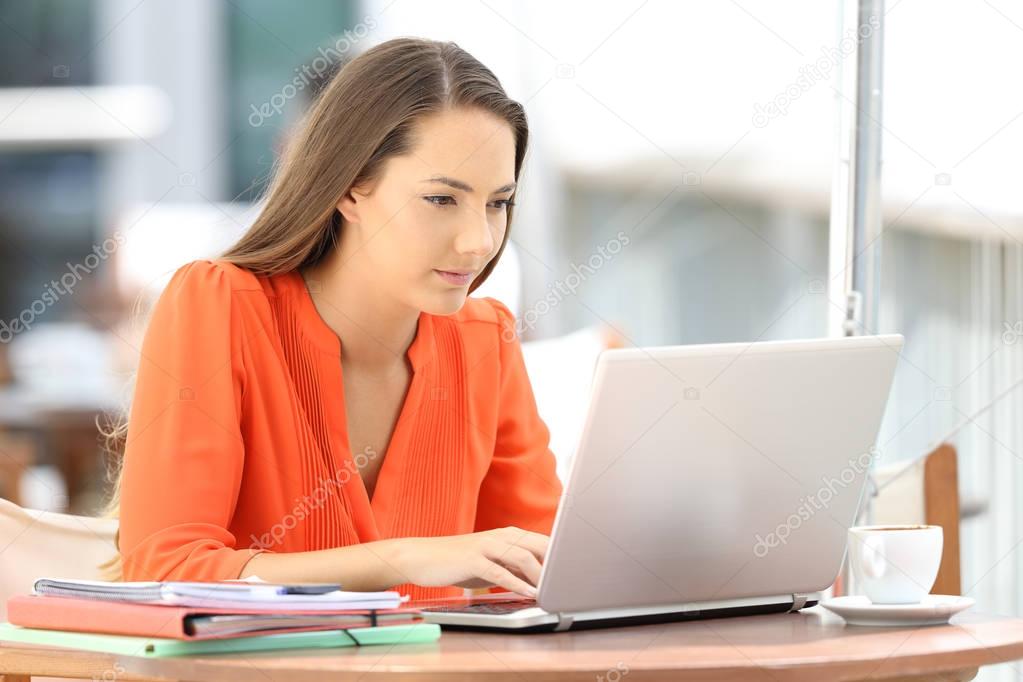College student using a laptop in a coffee shop