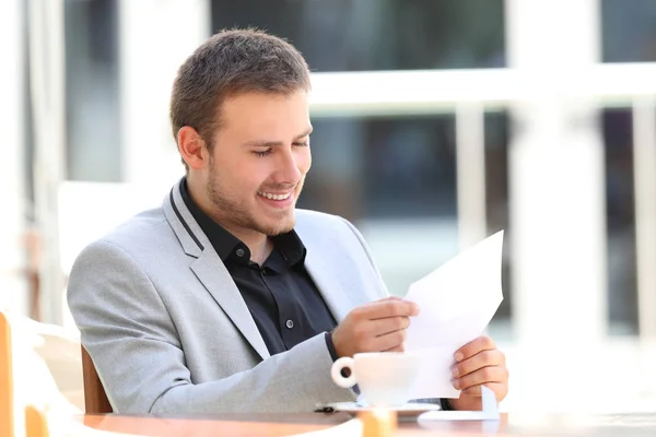 Happy executive reading a letter in a bar — Stock Photo, Image