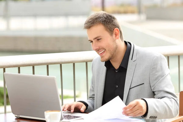 Executivo sorridente trabalhando on-line em uma cafeteria — Fotografia de Stock