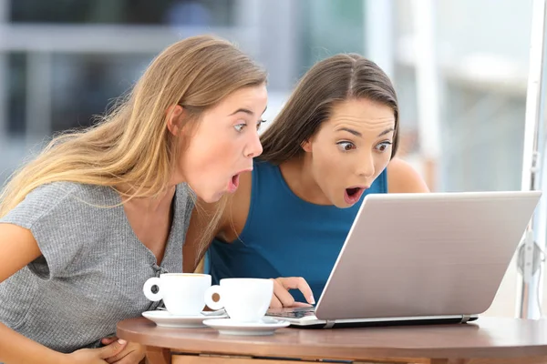 Amazed friends watching scandalous content in a bar Stock Photo