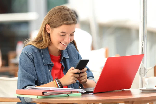 Vrolijke student texting op telefoon in een bar — Stockfoto