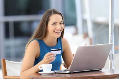 Happy buyer holding a credit card looking at you clipart