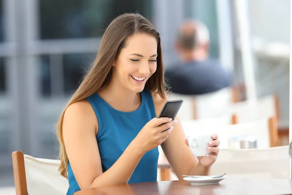 Wanita bahagia membaca pesan telepon di sebuah bar — Stok Foto