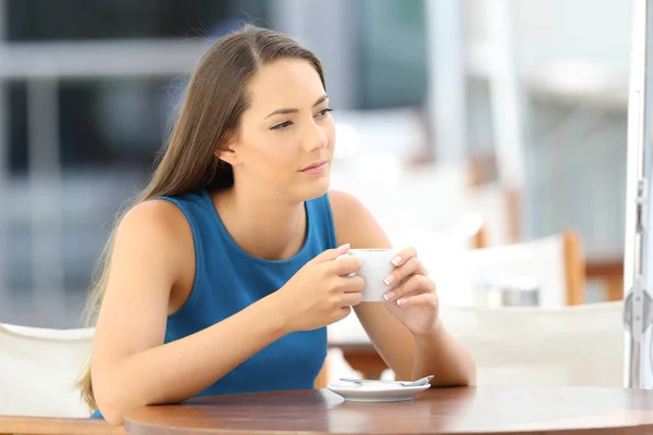 Nadenkend vrouw met een koffiemok in een bar — Stockfoto