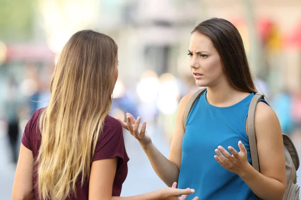 Двое друзей серьезно разговаривают на улице. — стоковое фото