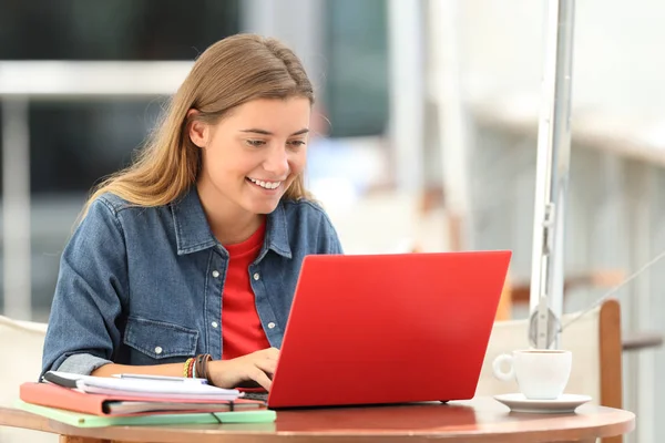Щасливий студент друкує на ноутбуці в барі — стокове фото