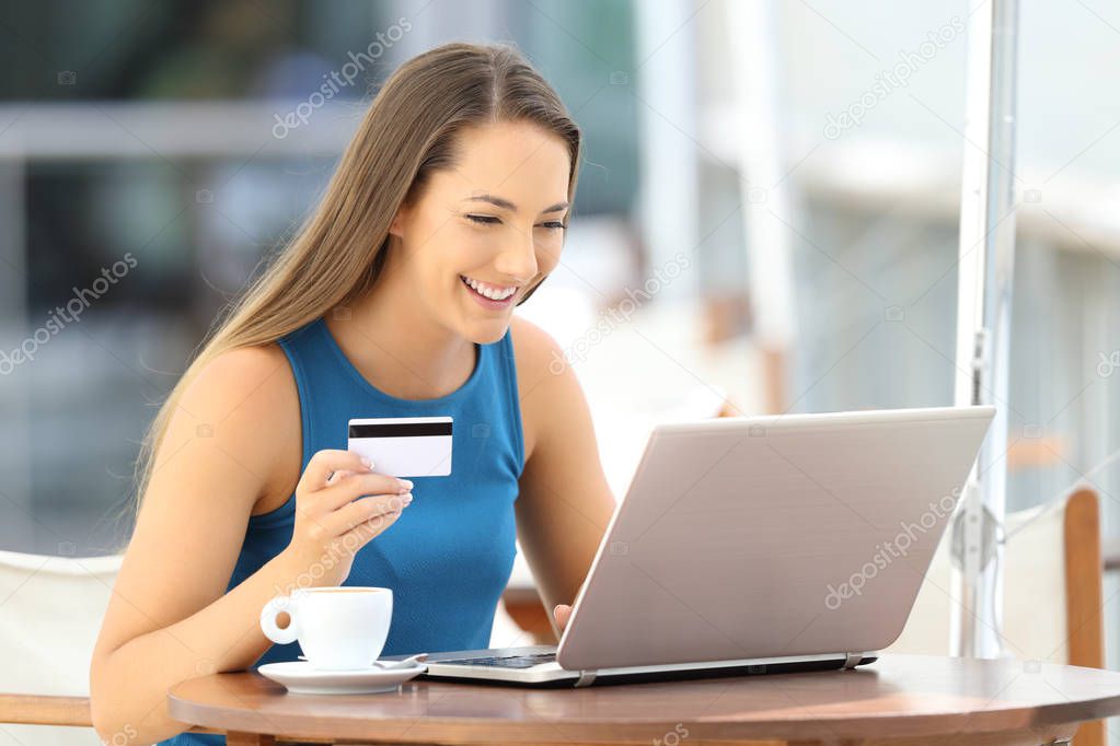 Happy woman paying on line in a restaurant
