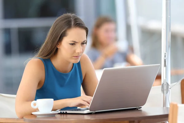 Mulher preocupada usando um laptop em um bar — Fotografia de Stock