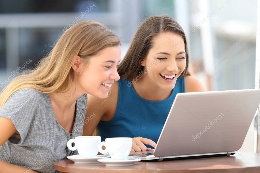 Two friends laughing wathing on line content