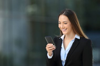 Sokakta bir cep telefonu kullanarak gülen icra