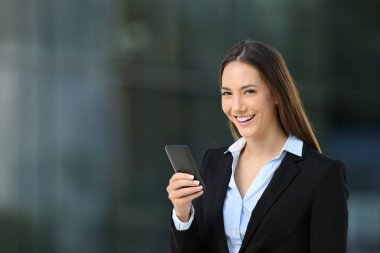 Telefon kullanarak ve kameraya bakarak mutlu icra