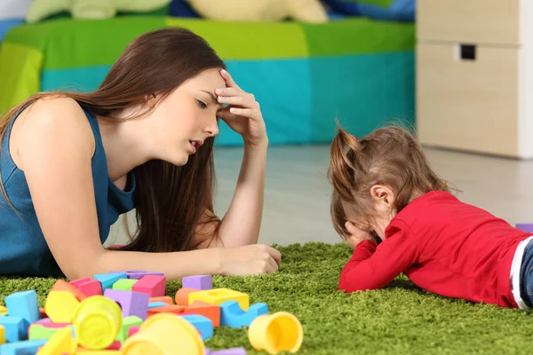 Arga barn och trött mamma i ett rum — Stockfoto