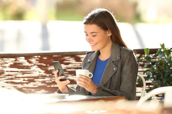 Fashion teen using a phone in a coffee shop — Stock Photo, Image