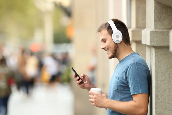 Профіль хлопця, який слухає музику на лінії на вулиці — стокове фото
