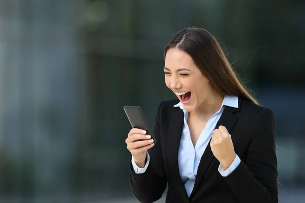 Excited executive reading amazing news on line — Stock Photo, Image