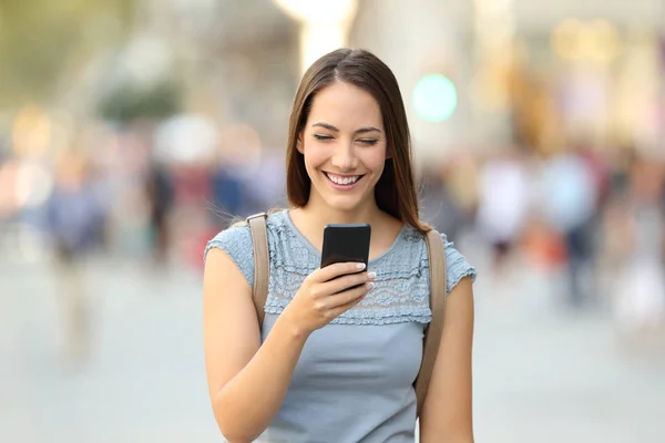 Вид спереду жінки, що використовує смартфон на вулиці — стокове фото