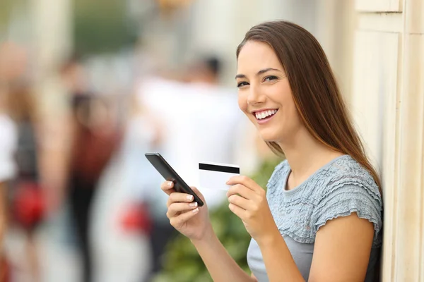On line shopper looking at camera holding card — Stock Photo, Image