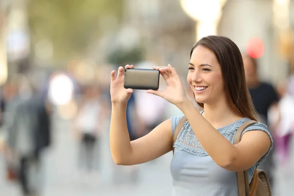 Mulher tirando fotos com um telefone inteligente — Fotografia de Stock