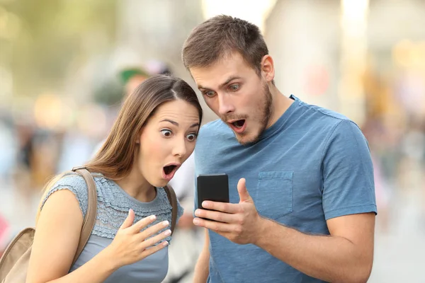 Удивительная пара смотрит на онлайн медиа в телефоне — стоковое фото