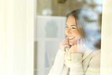 Mutlu kadın bir pencereden kışın arıyor
