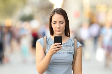 Ciddi kız sokakta telefon mesajı kontrol