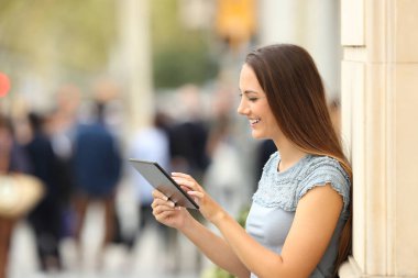Sokakta bir tablet kullanan bir kız yan görünüm