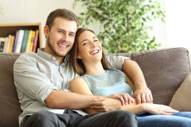 Mutlu çift evde kameraya bakarak poz