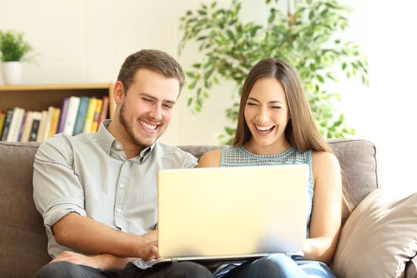 Paar lacht und schaut sich Online-Inhalte im Laptop an — Stockfoto