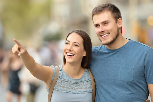 Pareja feliz encontrando la ubicación y señalando en la calle —  Fotos de Stock