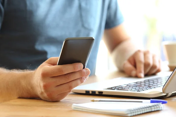 Mani uomo utilizzando uno smartphone su un desktop — Foto Stock