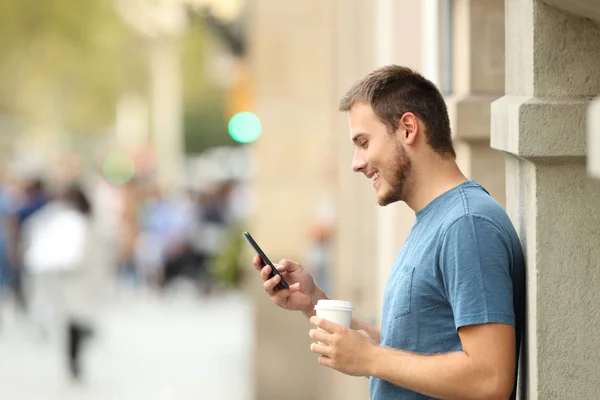 Widok z boku człowieka za pomocą smart telefonu na ulicy — Zdjęcie stockowe