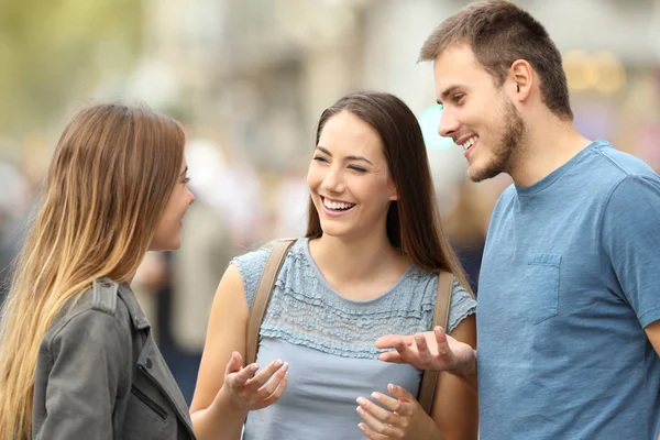 Trois amis souriants parlent debout dans la rue — Photo