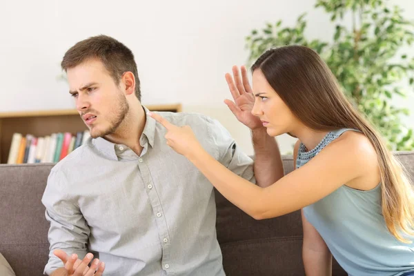 Pareja enojada discutiendo en un sofá en casa —  Fotos de Stock