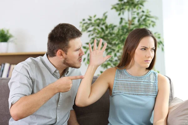 Розлючена пара бореться на дивані вдома — стокове фото