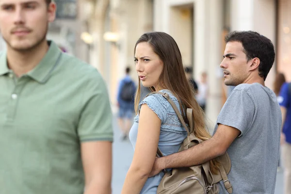 Mulher desleal procurando outro homem e seu namorado irritado — Fotografia de Stock