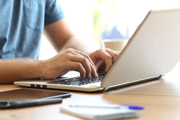 Mannen händerna att skriva på en laptop tangentbord på ett skrivbord — Stockfoto