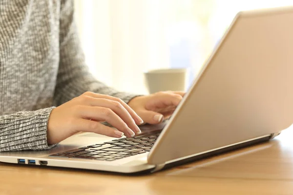 Mulher mãos digitando em um teclado de laptop em uma mesa — Fotografia de Stock
