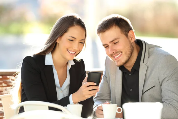 Dois executivos assistindo conteúdo on-line em um telefone — Fotografia de Stock