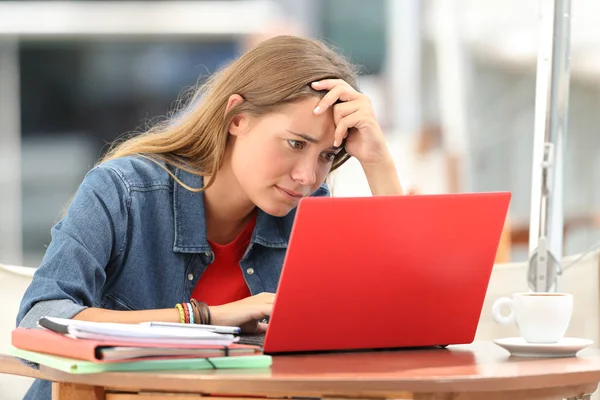 Siswa yang khawatir mencari di baris dalam laptop — Stok Foto